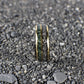 A sleek 8mm yellow gold ring with a domed design, featuring a mesmerizing meteorite inlay paired with earthy green moss agate.