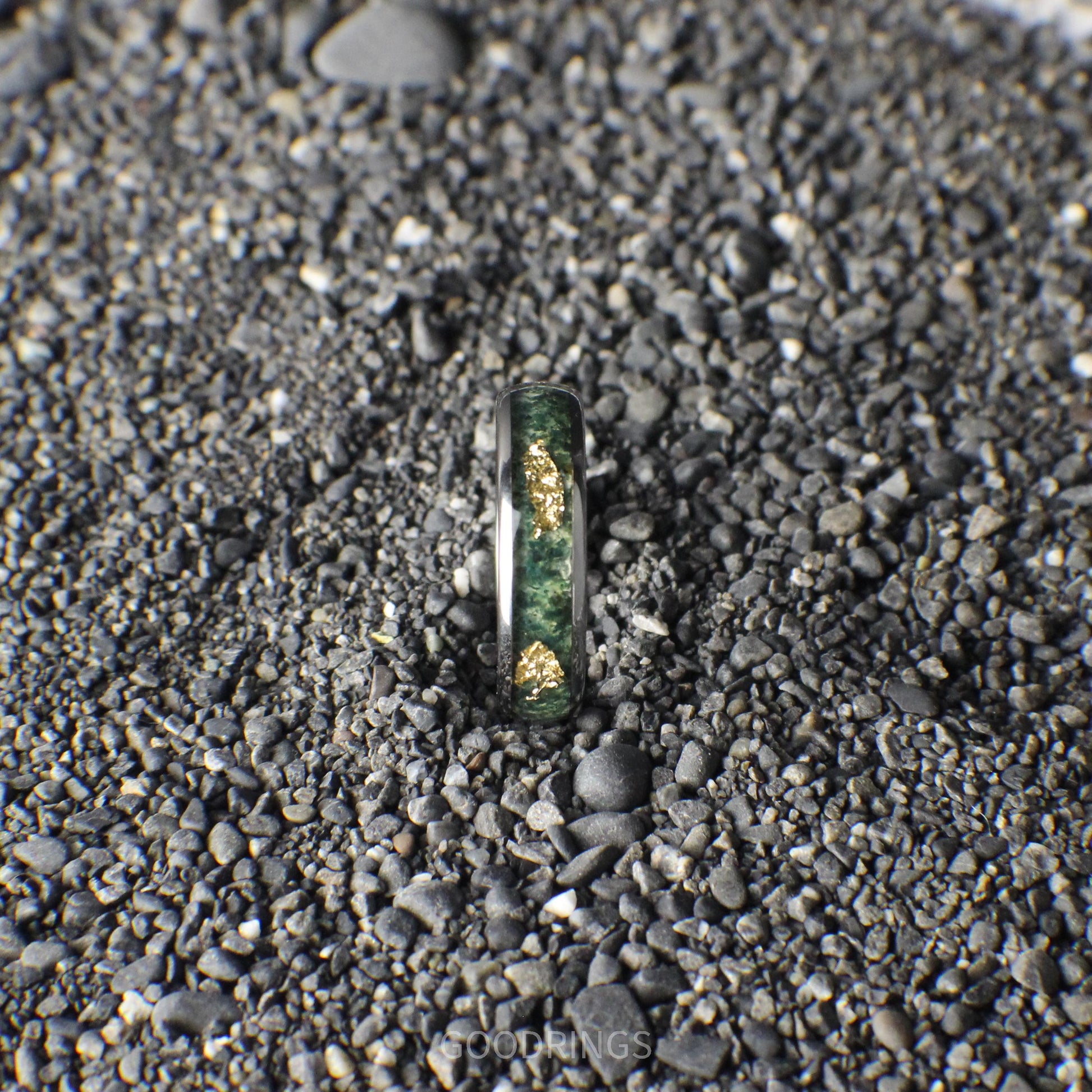 Close-up of a tungsten wedding band with moss agate and gold leaf inlay, showcasing earthy green tones and luxurious golden accents in a sleek 6mm design.