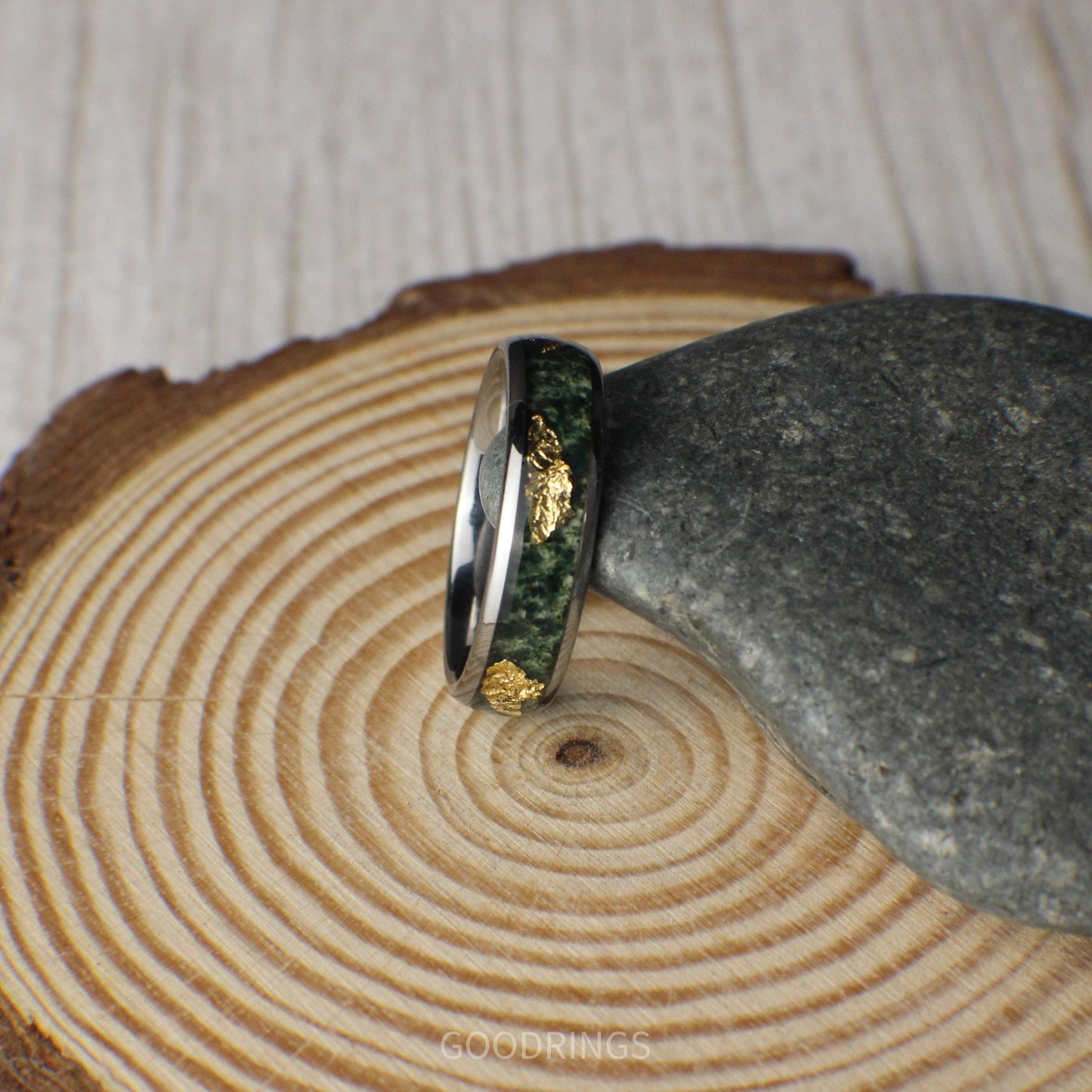 A 6mm tungsten ring featuring a polished finish with an inlay of vibrant moss agate and shimmering gold leaf, blending natural elegance with modern durability.